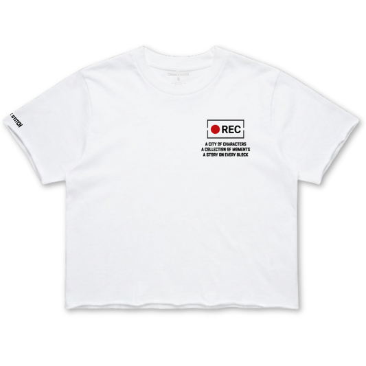 A white short-sleeve crop top t-shirt with a small black and red graphic on the left chest reading 'REC A CITY OF GUNNERS A COLLECTION OF MEMORIES A STORY BY EVERY WEEK'. The brand 'STUDY' is printed in black on the right sleeve.