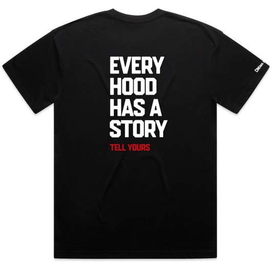 A black short-sleeve t-shirt shown from the back, featuring the slogan 'EVERY HOOD HAS A STORY' printed in large white block letters, with 'TELL YOURS' in smaller red text below. A small white brand tag is visible on the left sleeve.