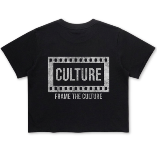 A black short-sleeve crop top t-shirt featuring a distressed white graphic on the front with a film strip border, the word 'CULTURE' in bold, and the phrase 'FRAME THE CULTURE' underneath.