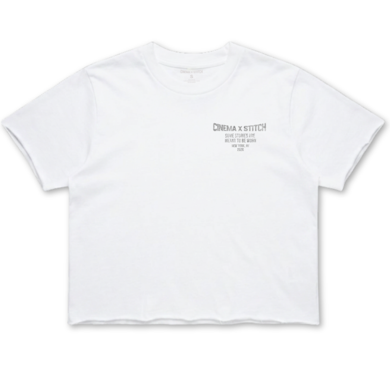 A white crop t-shirt with a small dark gray graphic on the left chest reading 'CINEMA X STITCH'.